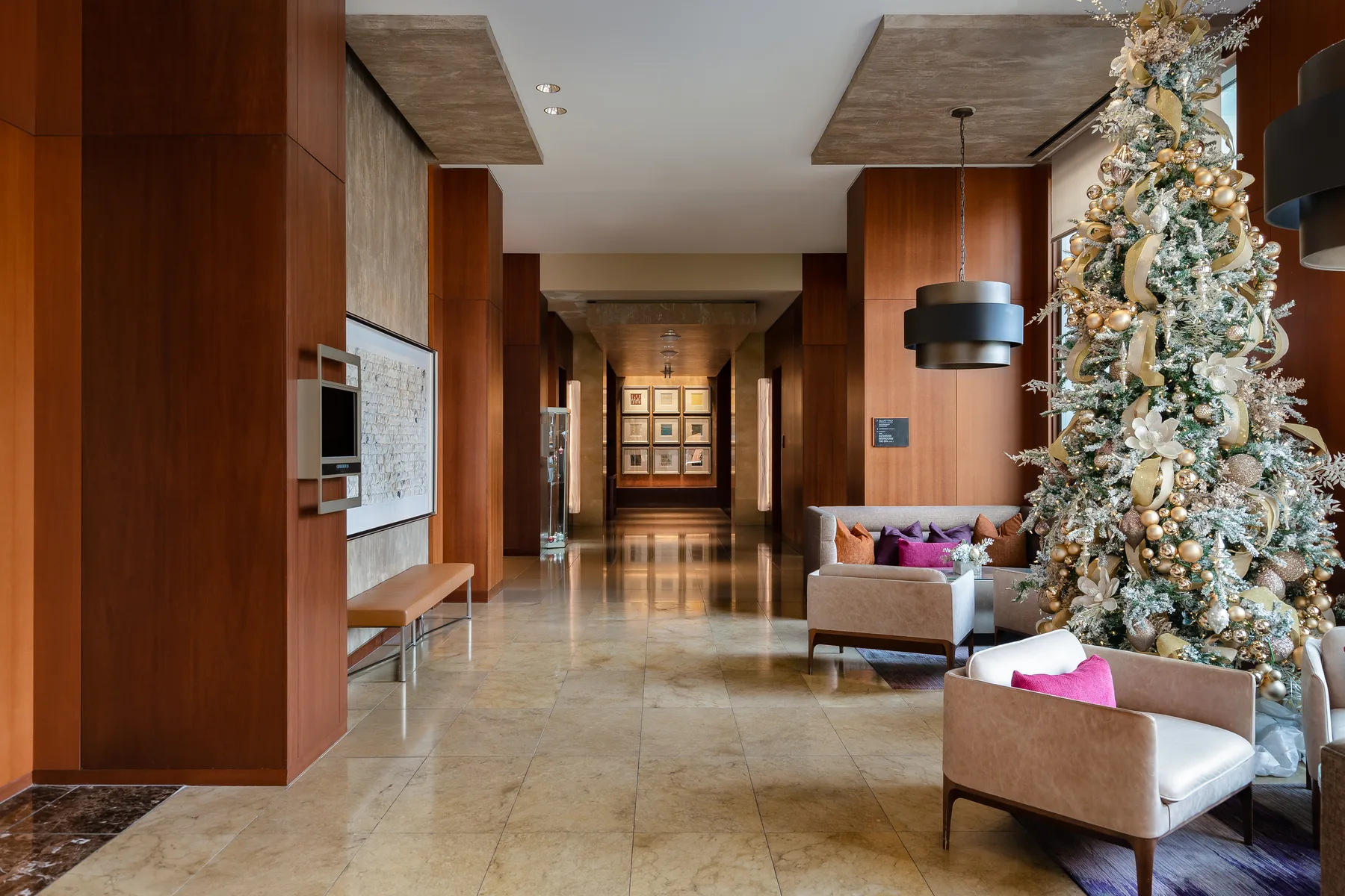 The Four Seasons Silicon Valley lobby at Christmas: a walnut-panelled corridor with a flocked tree and low seating