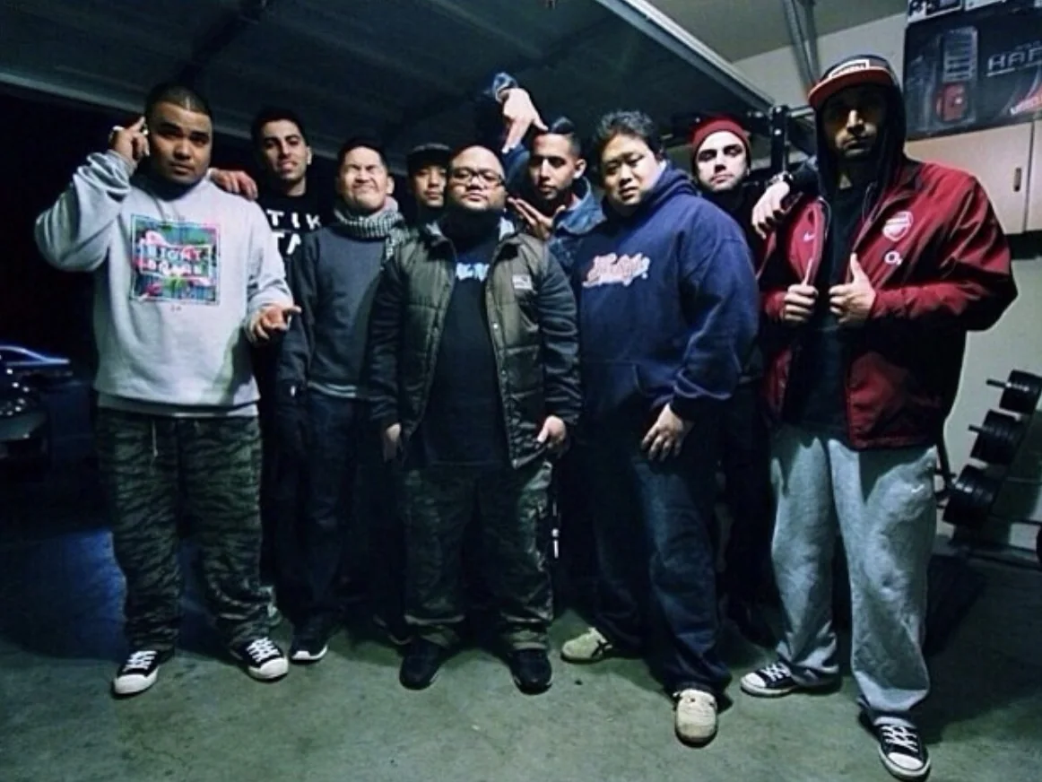Mike with his dance crew, lined up in a garage.
